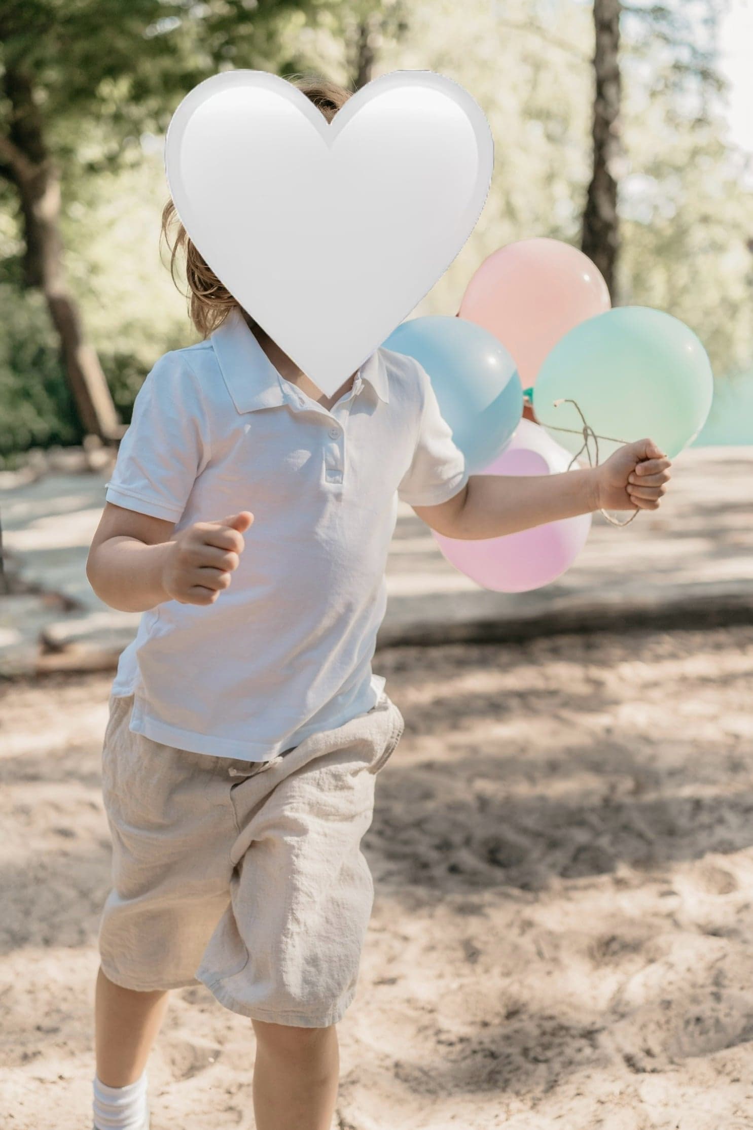 Junge läuft mit bunten Luftballons durch den Park