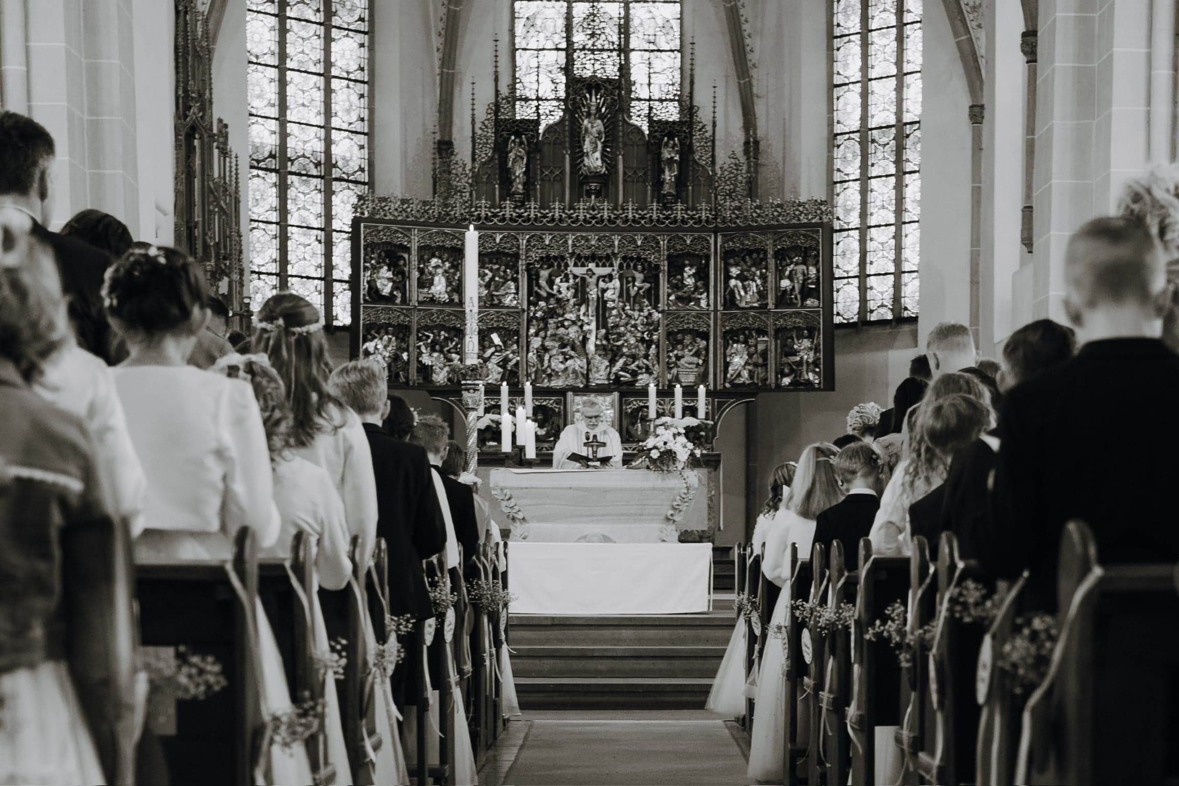 Kommuniongottesdienst mit Blick durch den Mittelgang auf den Altar, in Schwarzweiß